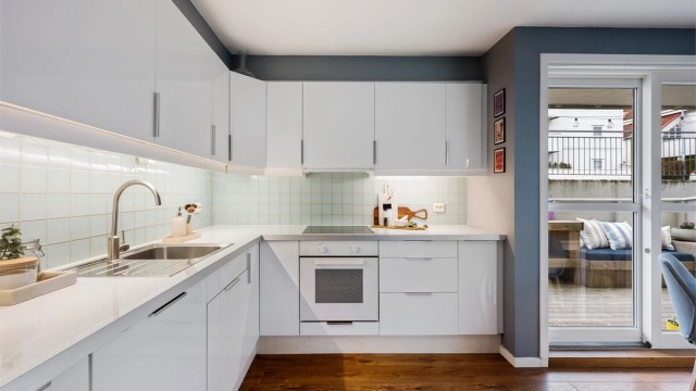 Godt med benkeplass og oppbevaring i skuffer og skap. Fliser mellom benk og overskap.