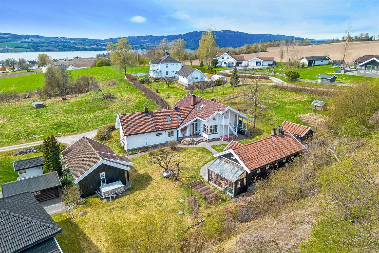 Tunet består av hovedhus, uthus, dobbel carport med bod og eget hønsehus, og gir en variert og fleksibel eiendom med mange bruksområder.