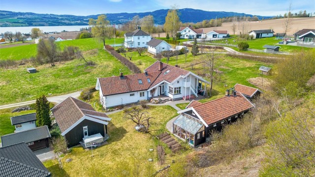 Tunet består av hovedhus, uthus, dobbel carport med bod og eget hønsehus, og gir en variert og fleksibel eiendom med mange bruksområder.