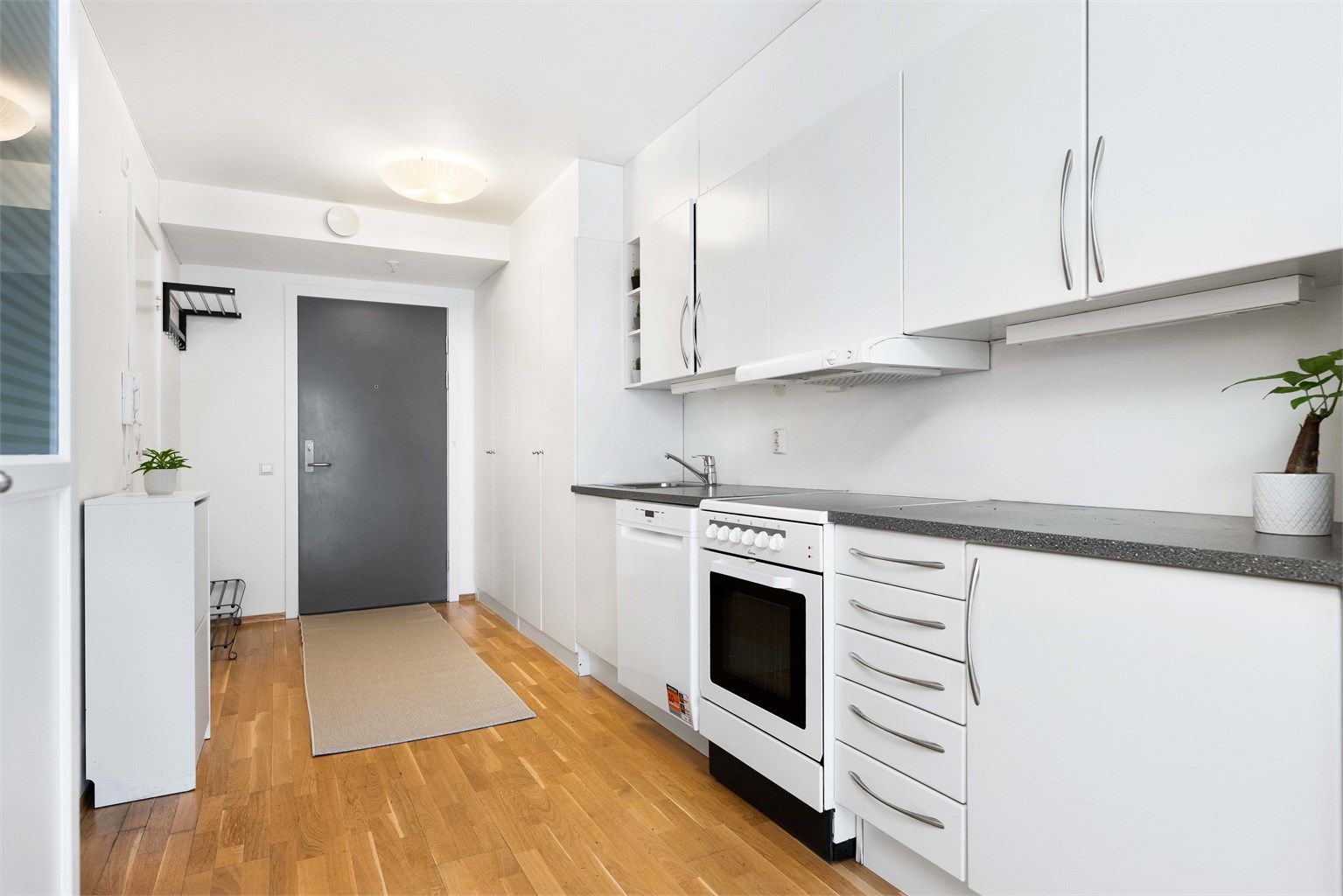 Kjøkkenet har innredning fra byggeår med glatte fronter og laminert benkeplate.