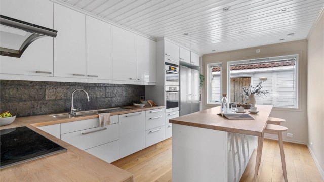 Romslig kjøkken med spiseplass.
Kjøkkeninnredningen fra IKEA ( 2012), i tidløs hvit og benkeplate av tre