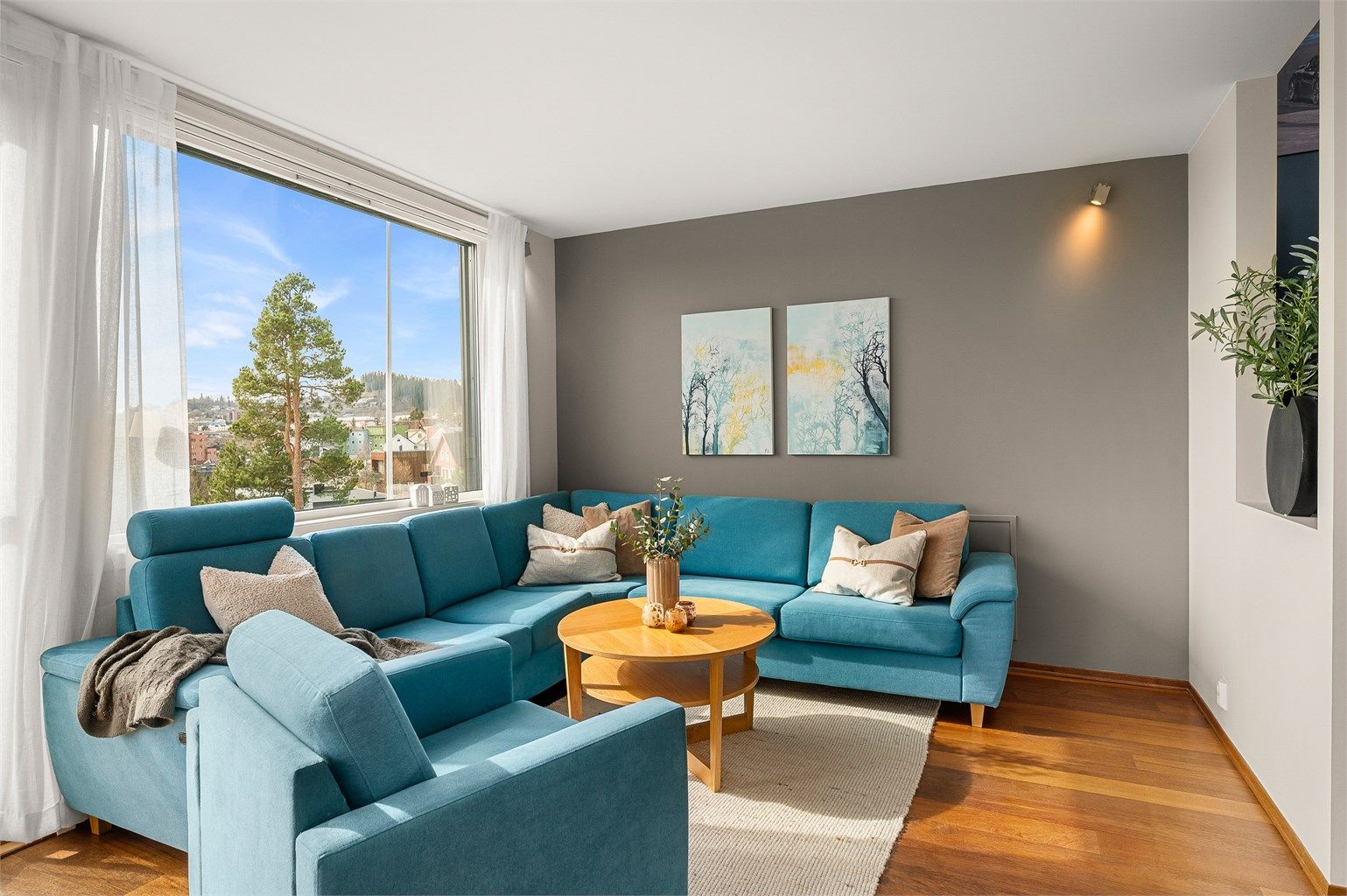 Stuen oppleves lys og romslig, med god plass til sofagruppe og en naturlig sammenheng videre mot kjøkken og spisestue.