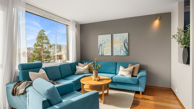 Stuen oppleves lys og romslig, med god plass til sofagruppe og en naturlig sammenheng videre mot kjøkken og spisestue.