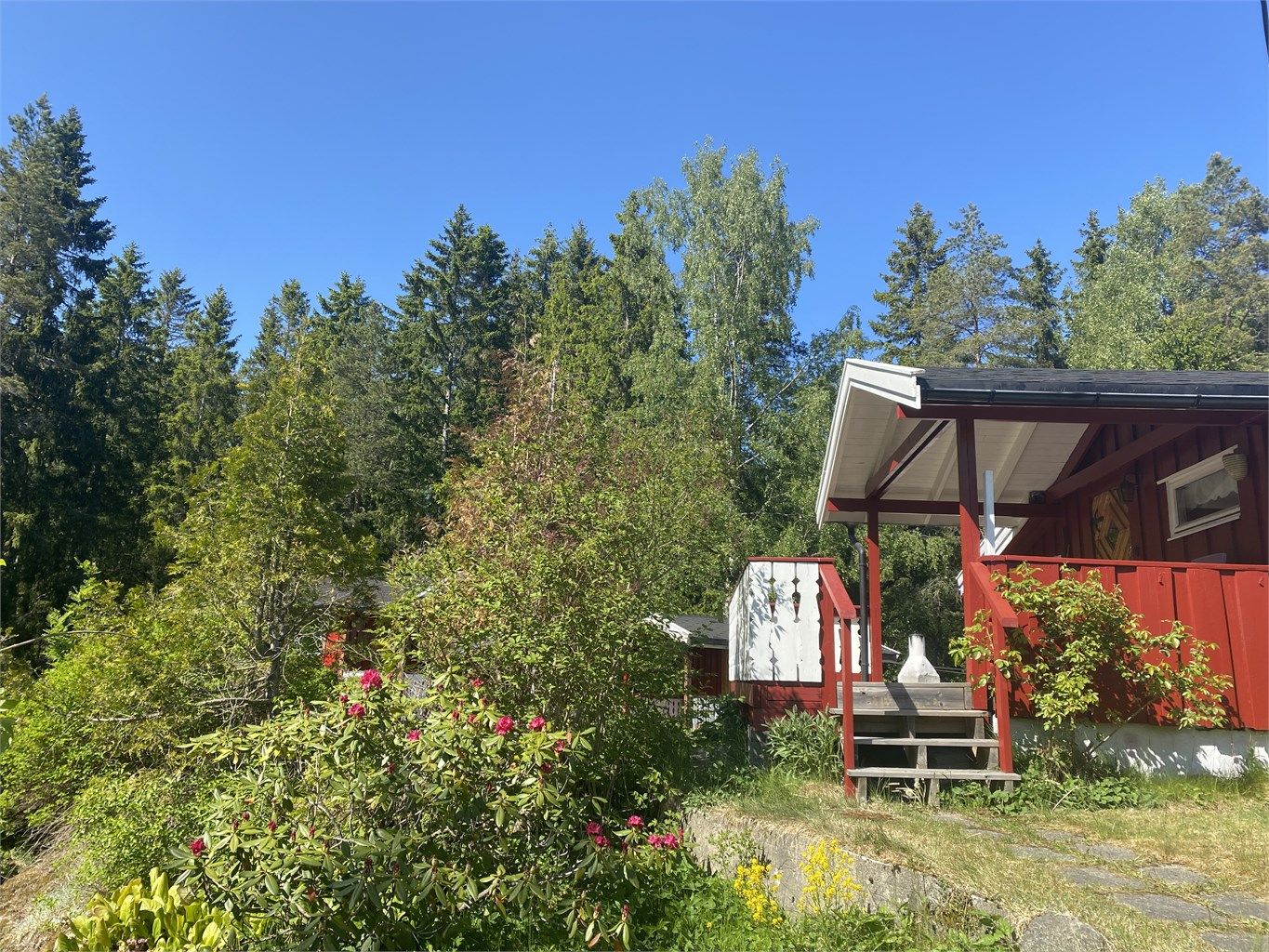 Eiendommen består hovedsakelig av naturtomt, men har mye blomster, busker og frukttrær