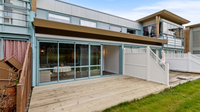 Vestvendt terrasse med god plass til utemøbler og direkte overgang til felles plener.
