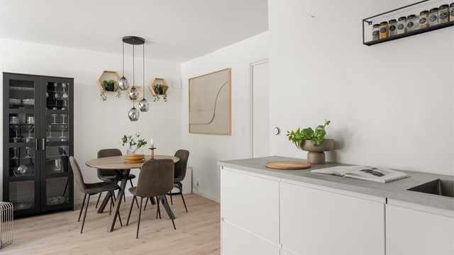 Benkeplate i laminat og slette, hvite fronter gir et stilrent uttrykk.