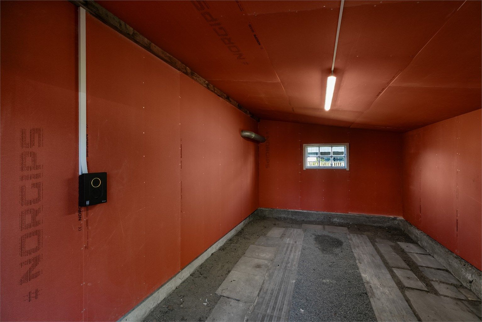 I garasjen er ladeboks til EL-bil installert og gipsplater montert under tak og på vegger.