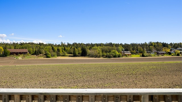 Vid utsikt fra altanen over åkerlandskapet som om våren blir grønt og vakkert.