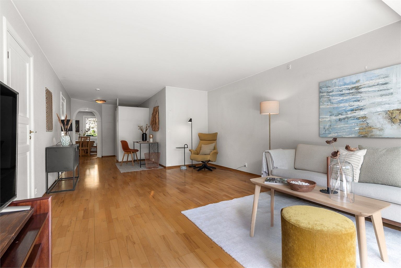 Lys og romslig stue med flere møbleringsmuligheter. Her er det plass til sittegruppe, TV-område og spisebord.