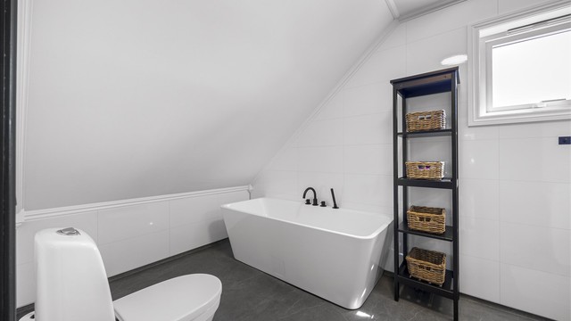 Badet på loftet er innredet med et frittstående badekar. Rommet ble pusset opp i nyere tid.