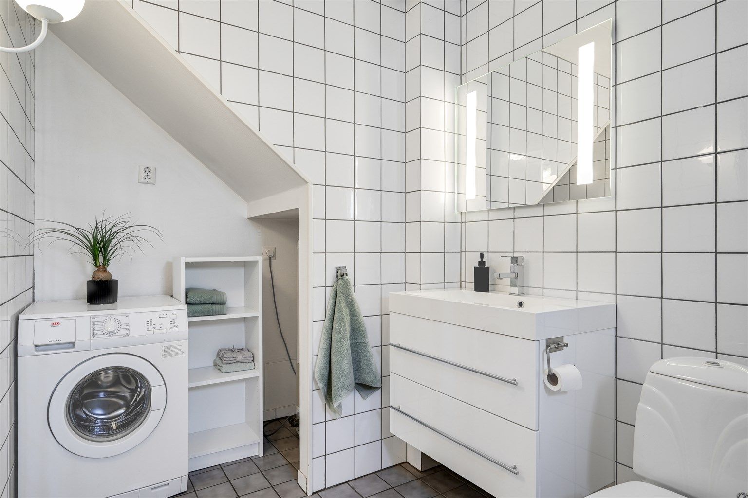 Rommet fungerer også som vaskerom, med praktisk opplegg for vaskemaskin.