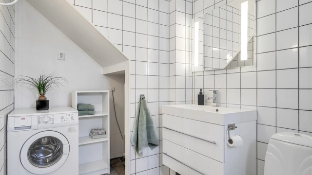 Rommet fungerer også som vaskerom, med praktisk opplegg for vaskemaskin.