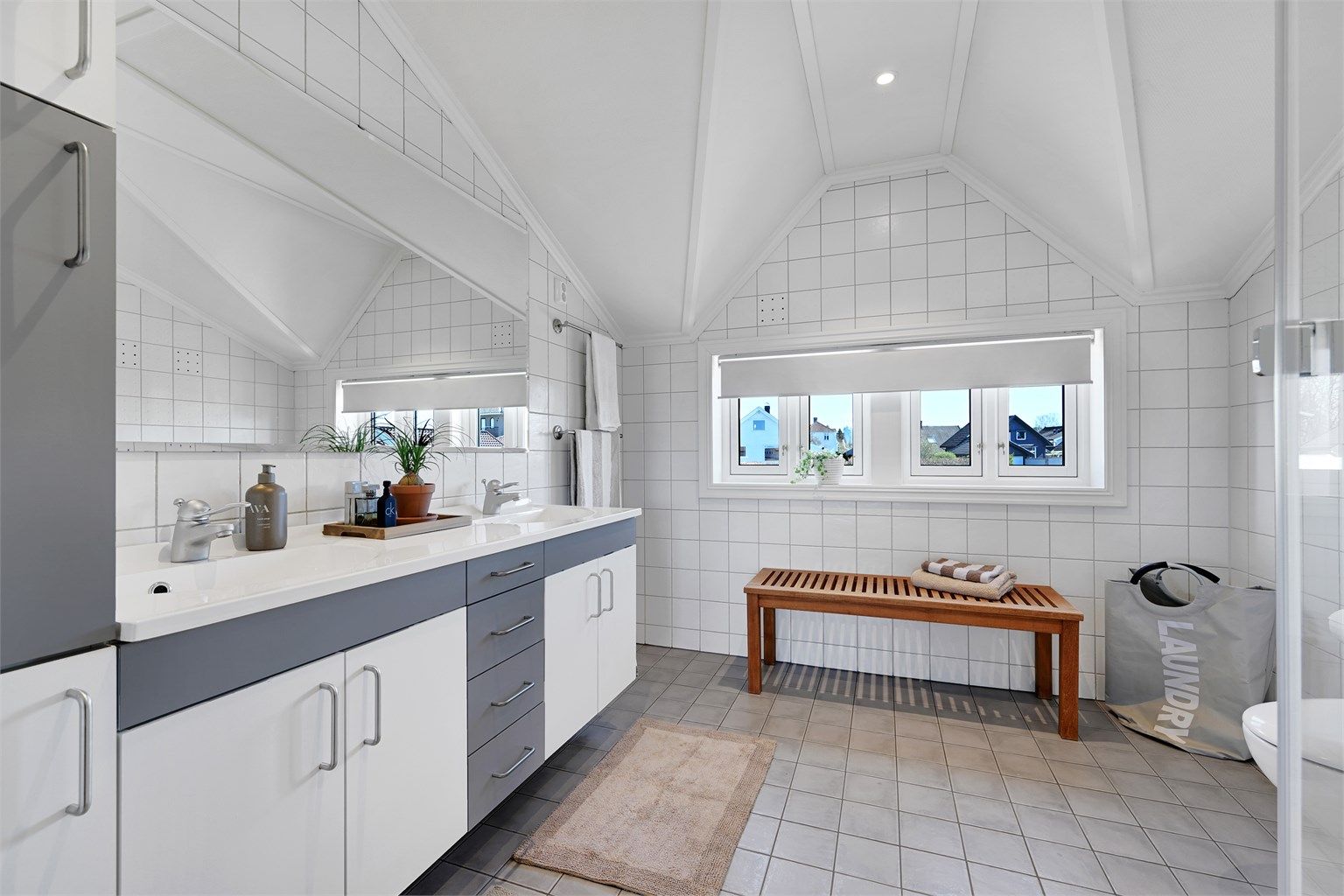 Badet i andre etasje er utstyrt med dusjkabinett, doble servanter og elektriske varmekabler i gulvet.