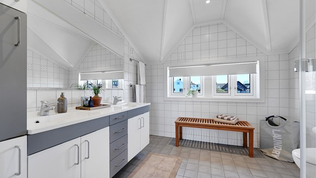 Badet i andre etasje er utstyrt med dusjkabinett, doble servanter og elektriske varmekabler i gulvet.