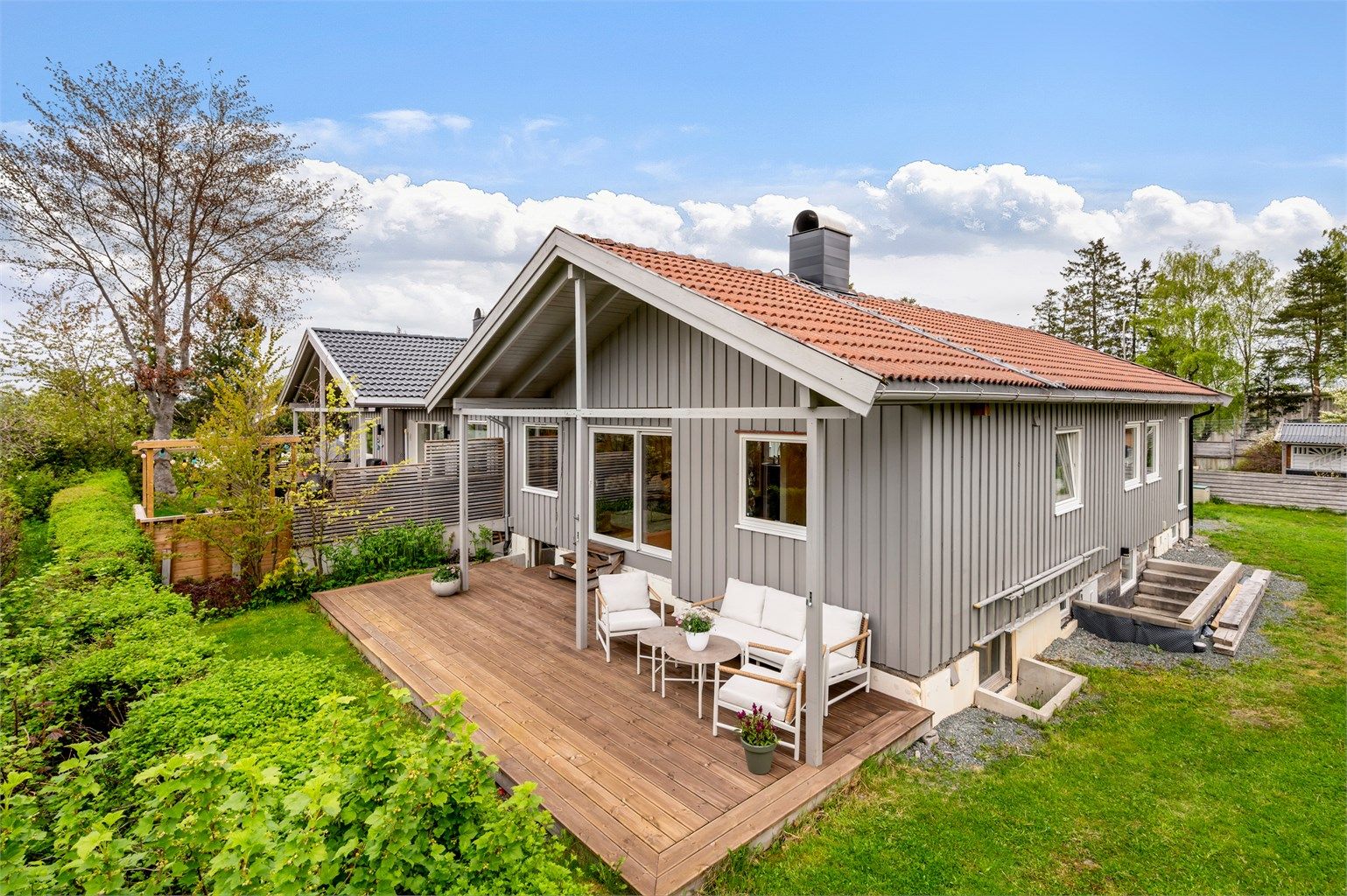 Fra stuen har man direkte utgang til en delvis overbygd markterrasse i lune og solfylte omgivelser. 