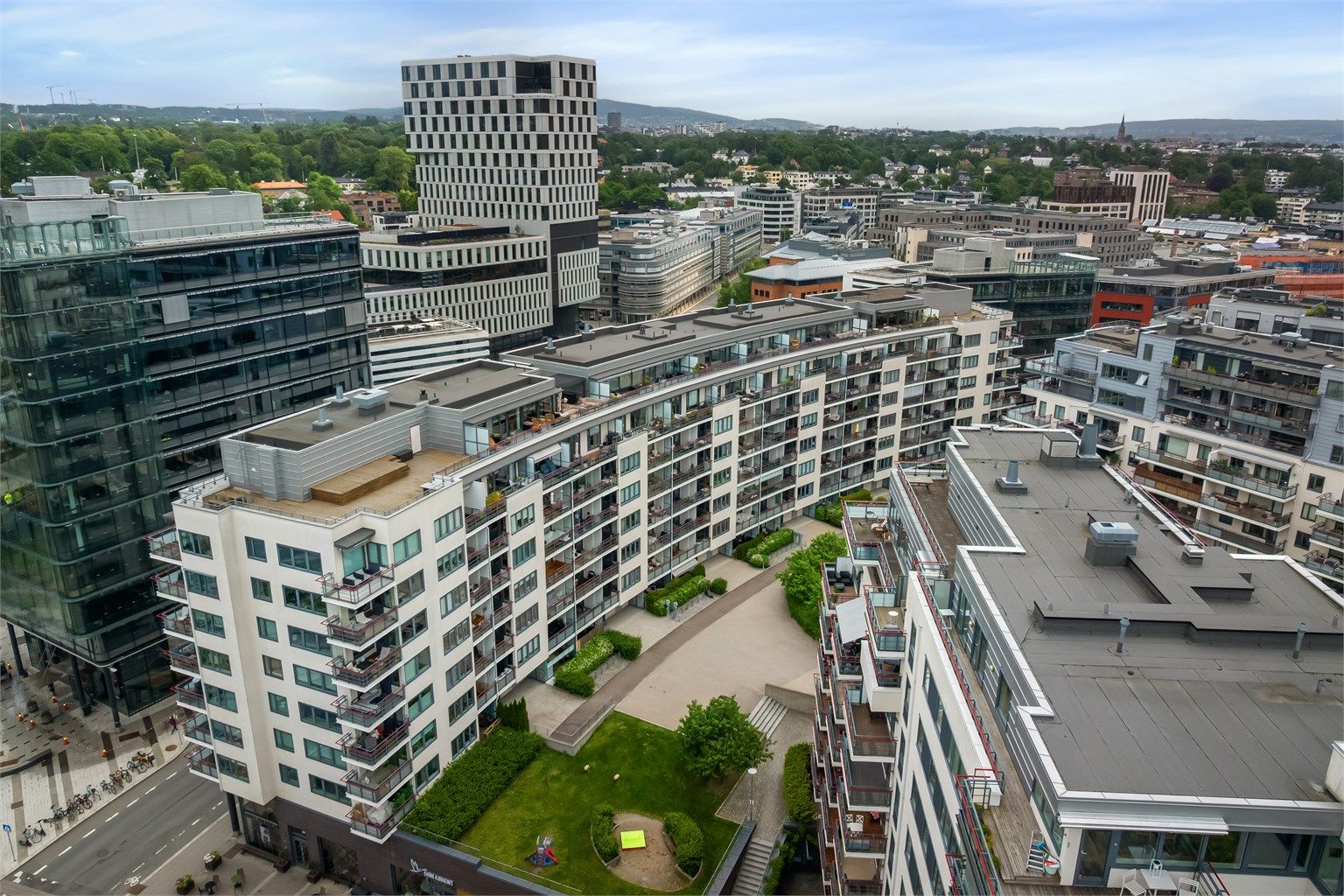 Leiligheten ligger i en moderne bygård med fasader av murpuss.