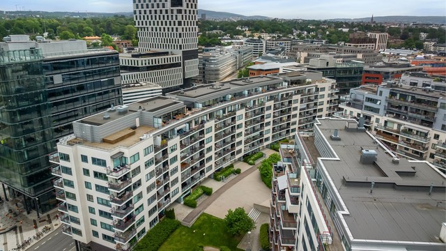 Leiligheten ligger i en moderne bygård med fasader av murpuss.