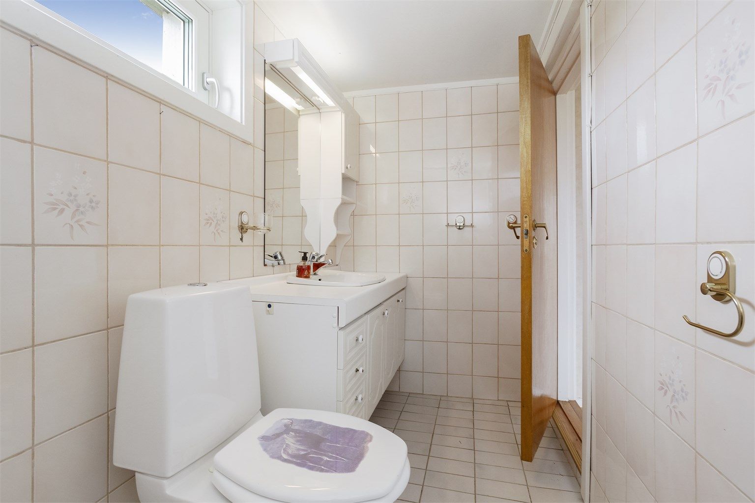 Baderomsinnredning med profilerte fronter og heldekkende servant.