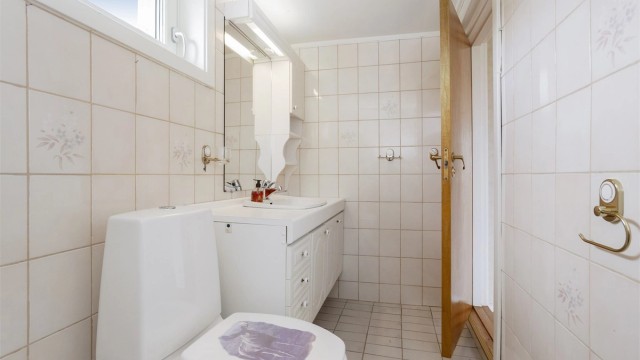 Baderomsinnredning med profilerte fronter og heldekkende servant.