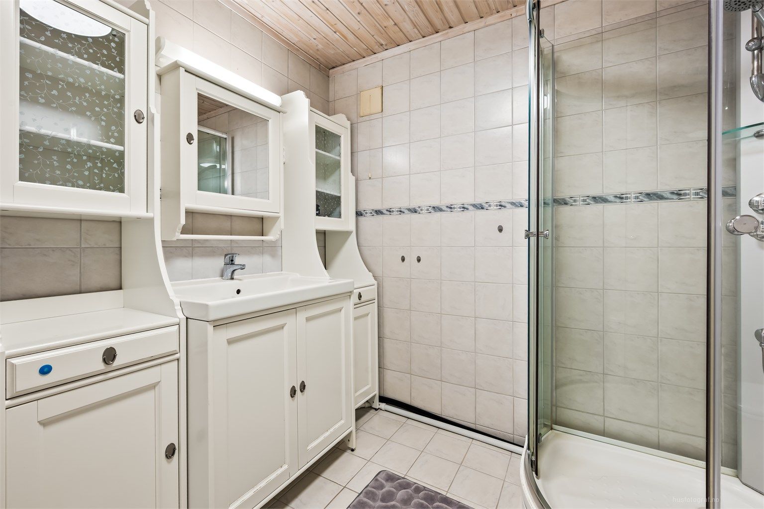 Badet i underetasjen er innredet med servantmøbel og dusjkabinett.