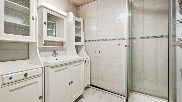 Badet i underetasjen er innredet med servantmøbel og dusjkabinett.