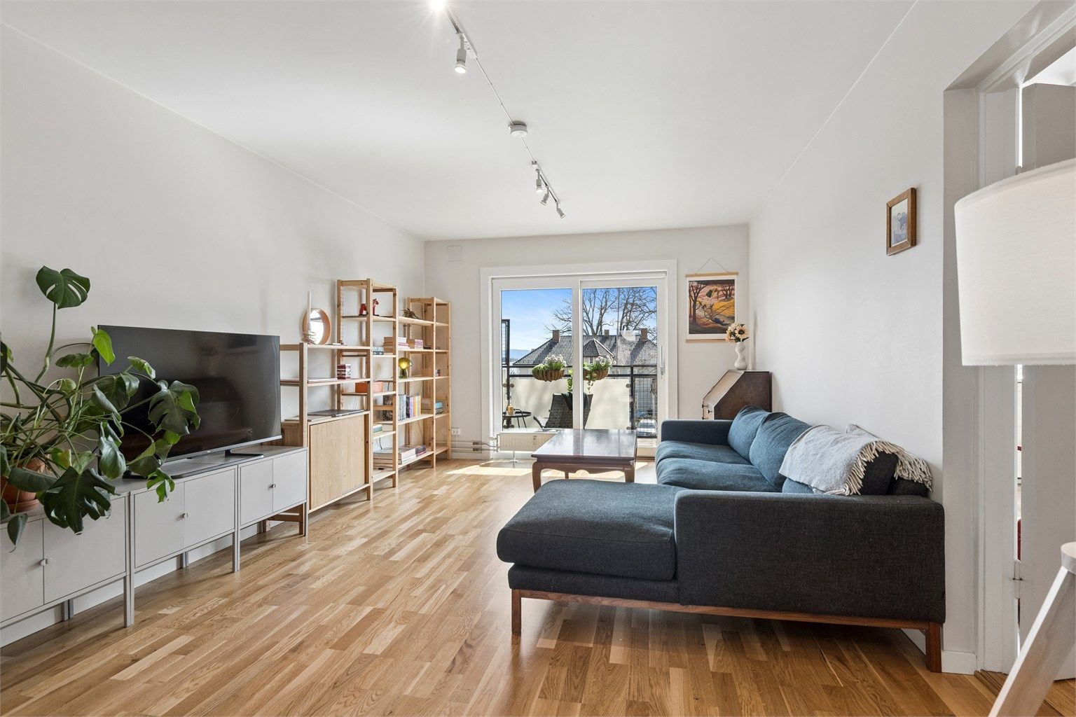 Stor og lys stue med utgang til balkong. Foto: EFKT v/Jonas Hasselgren