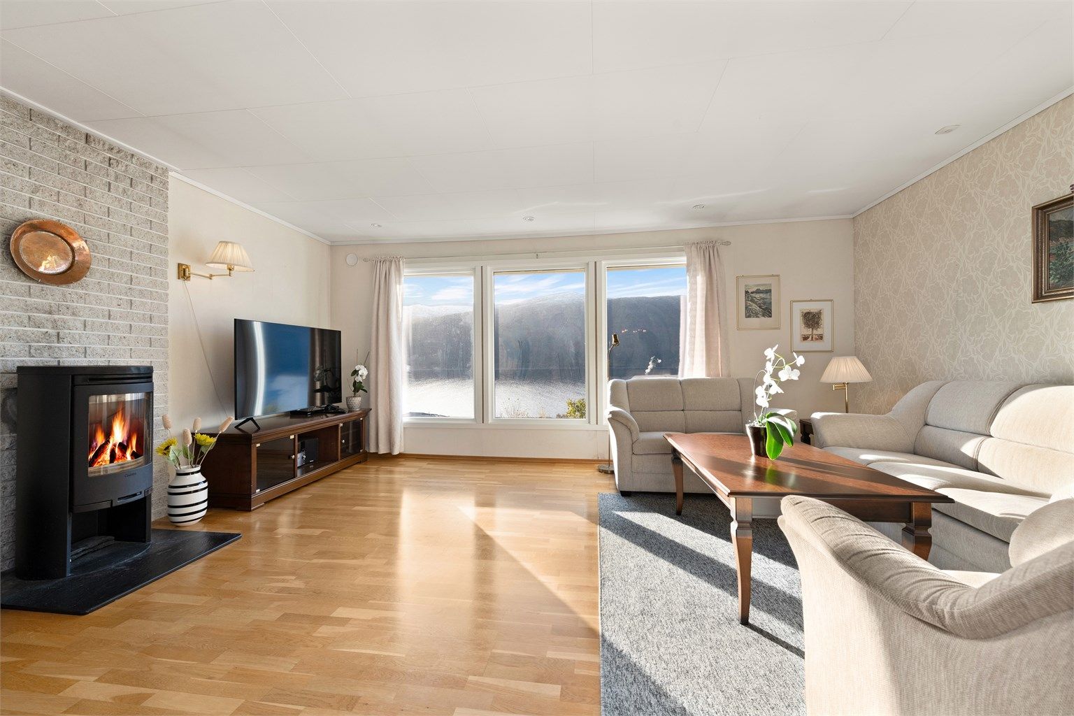 I stuen i hovedetasjen er det peisovn med glassdør som gir en lun og hyggelig atmosfære på kjølige dager