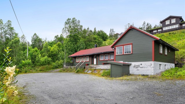 Eiendommen har en stor, gruset gårdsplass med enkel adkomst fra veien.
