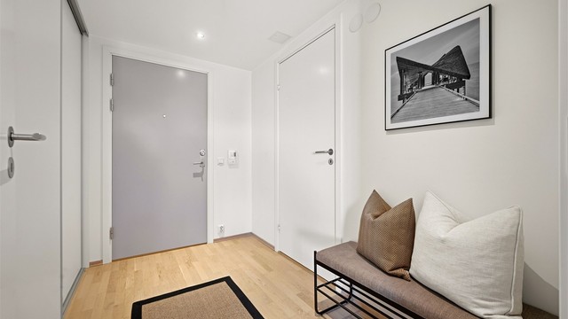 Entréen har nedsenket himling med downlights og en takhøyde på ca. 2,21 meter. Praktisk garderobe/bod til venstre.