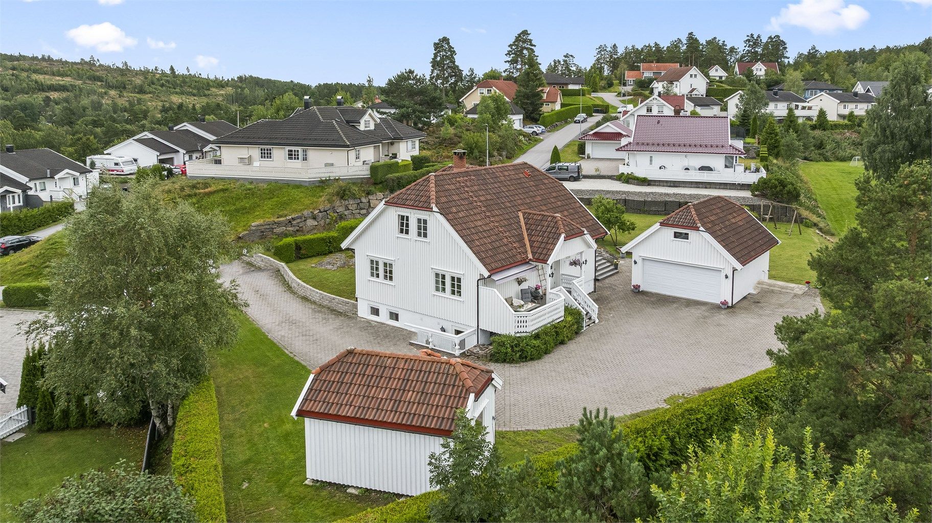 Eiendommen har en romslig gårdsplass med god plass til flere biler, samt en stor garasje og en praktisk bod med rikelig lagringsplass.