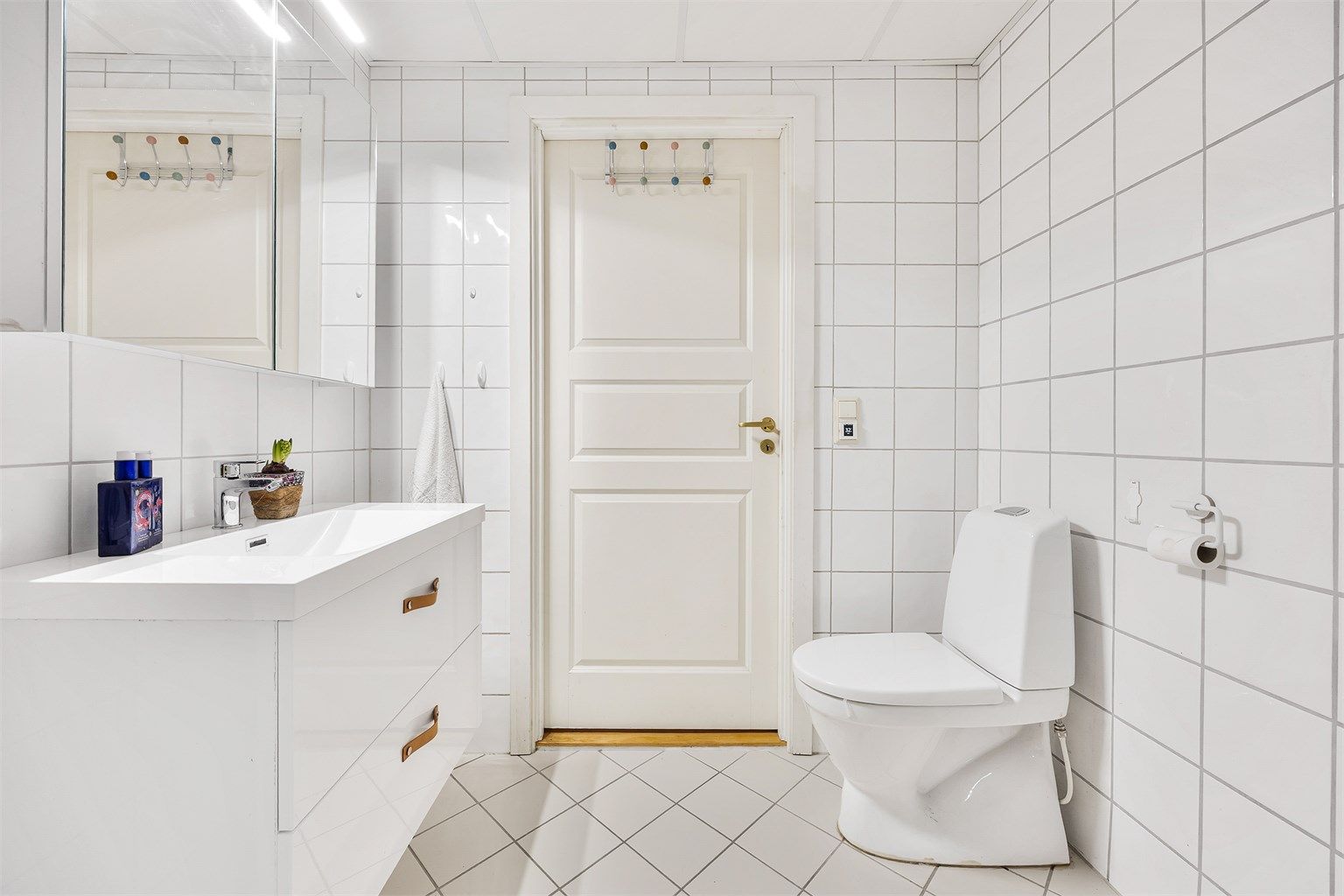 Badet har en stilren innredning fra Megaflis og behagelig gulvvarme.