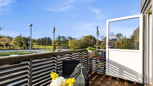 Balkong i trekonstruksjon med terrassebord på gulvet og utsyn mot omgivelsene.