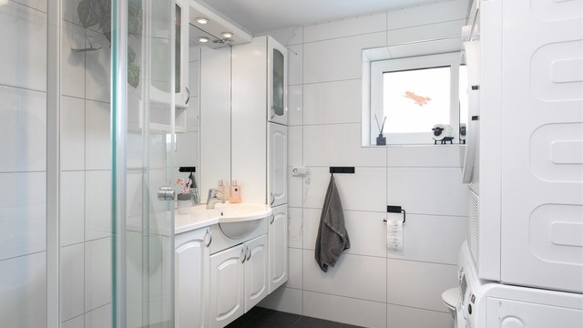 Romslig innredning med nedfelt servant, toalett, dusjakabinett og opplegg for vaskemaskin. Elektrisk styrt vifte.