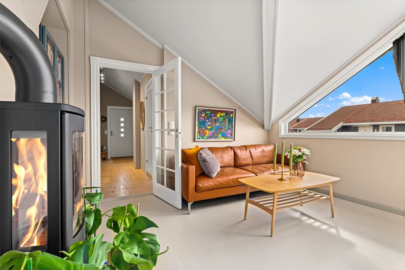 Peisovnen i stuen gir en lun atmosfære, supplert av en effektiv varmepumpe installert i 2022.