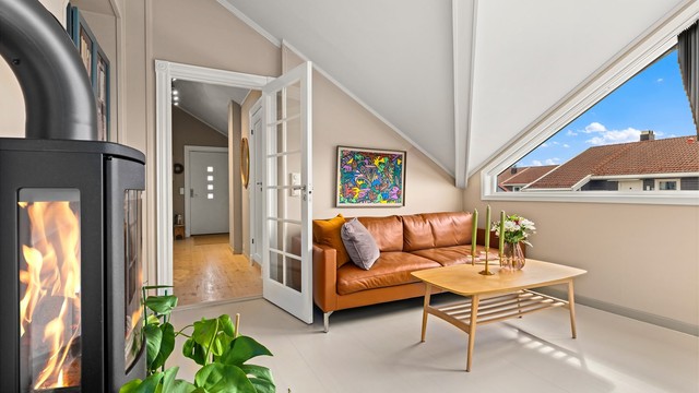 Peisovnen i stuen gir en lun atmosfære, supplert av en effektiv varmepumpe installert i 2022.