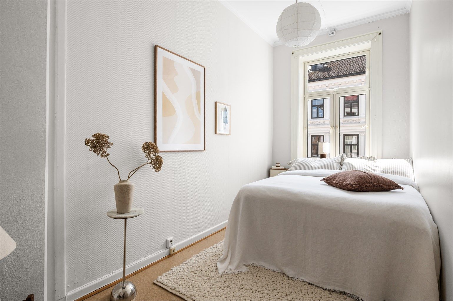 Rommet har en god størrelse med plass til dobbeltseng og øvrig møblering, samtidig som de store vinduene slipper inn rikelig med dagslys.