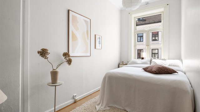 Rommet har en god størrelse med plass til dobbeltseng og øvrig møblering, samtidig som de store vinduene slipper inn rikelig med dagslys.