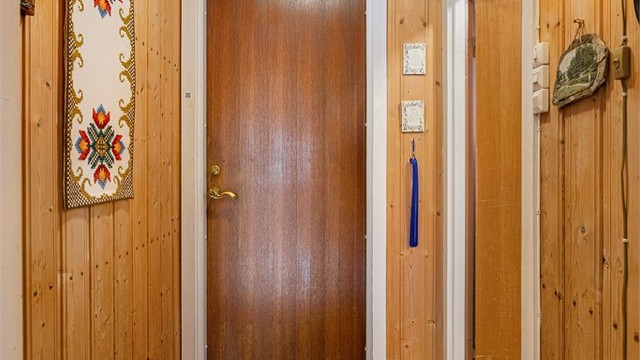Inngangspartiet ønsker velkommen med panelkledde vegger og laminat på gulvet.