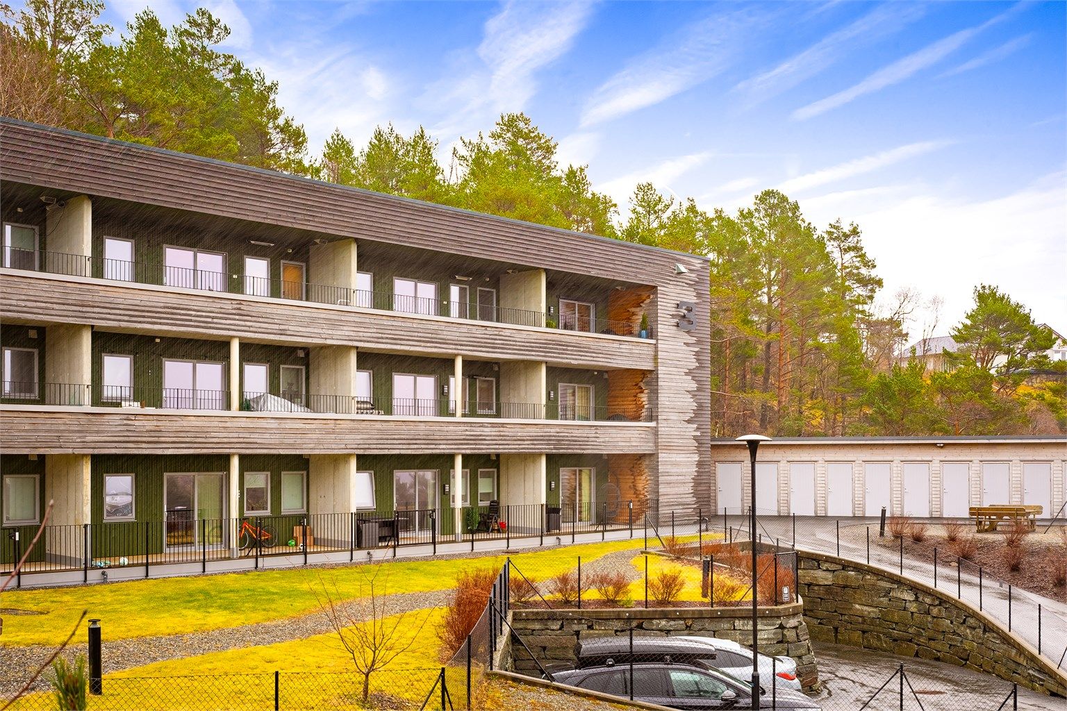 - Lekker og moderne fasade. Legg også merke til bodene til høyre i bildet, og gjesteparkeringen nederst. -