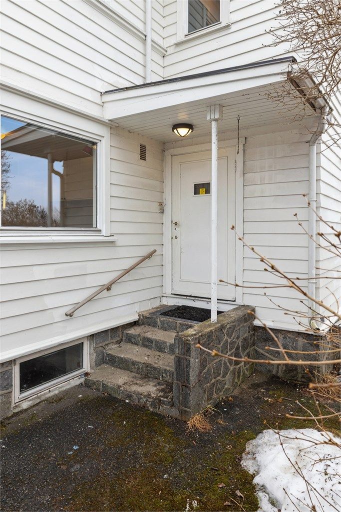 Overbygget inngangsparti med trapp i stein- og murkonstruksjoner.