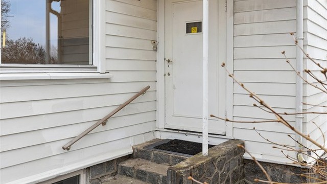 Overbygget inngangsparti med trapp i stein- og murkonstruksjoner.