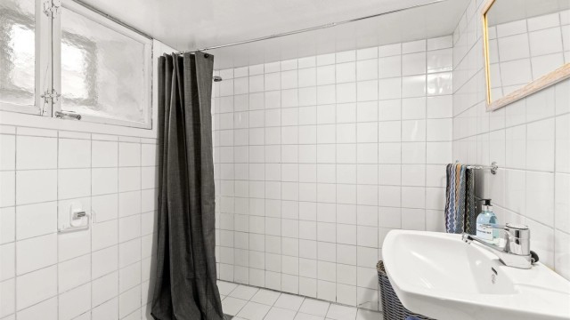 Flislagt bad i kjelleren med gulvvarme, toalett og dusj.