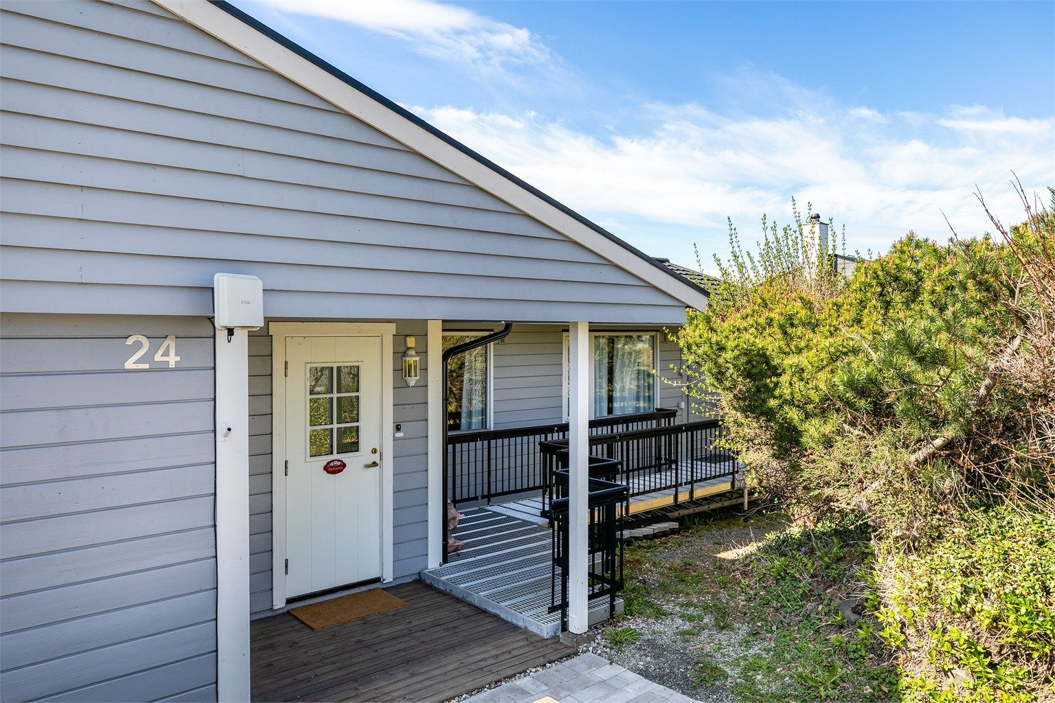 Inngangspartiet har trappefri adkomst og er godt skjermet fra både nedbør og vind.