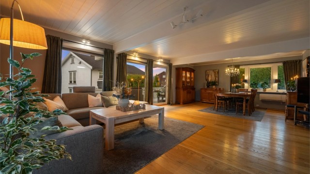 Store, sosiale oppholdsrom i første etasje med parkettgulv og gjennomgående planløsning.