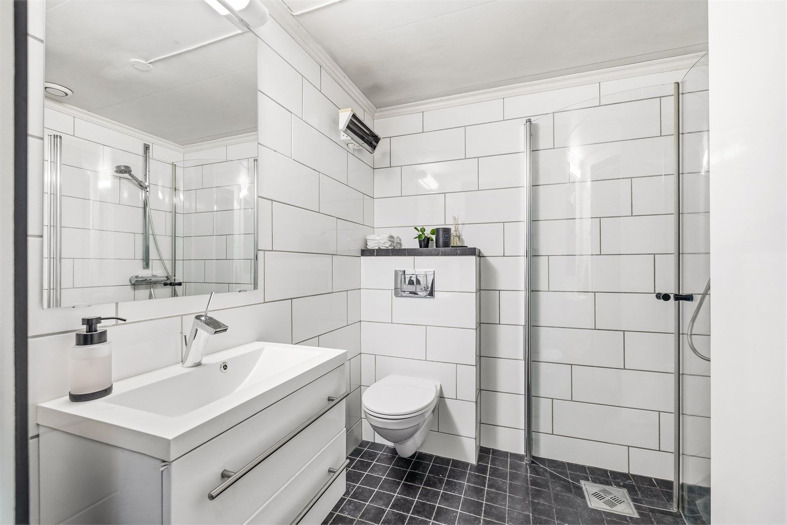 Badet ble modernisert i 2012 og har flislagt gulv med gulvvarme, vegghengt toalett og dusjhjørne.