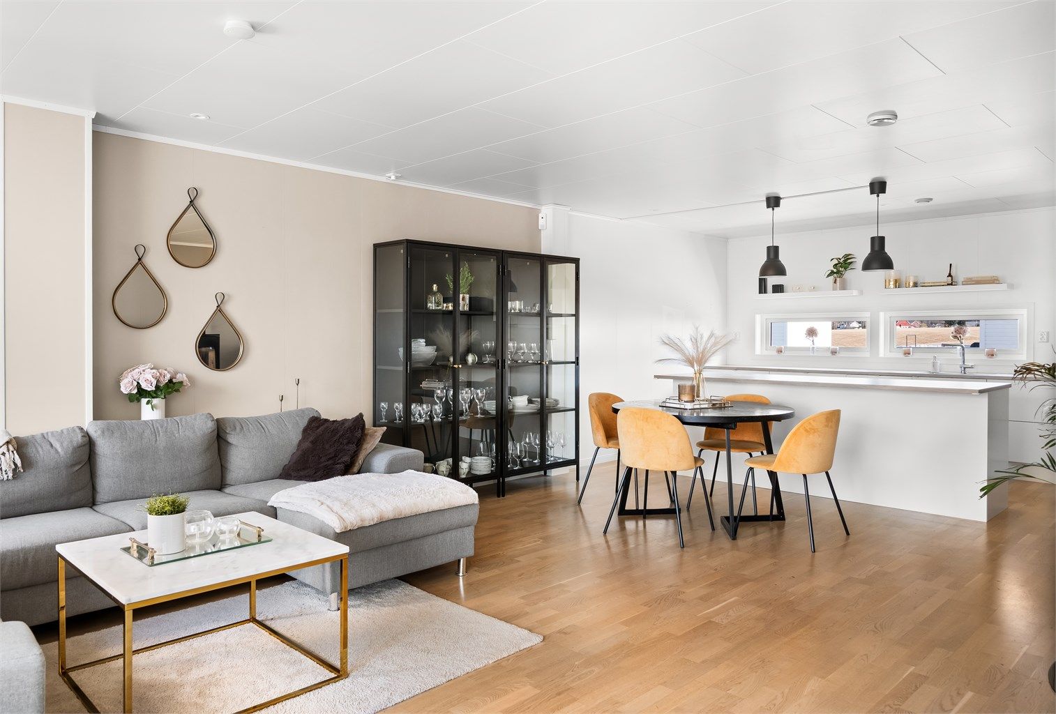 Gjennomgående parkett binder sammen stue og kjøkken. Downlights i taket gir god grunnbelysning.