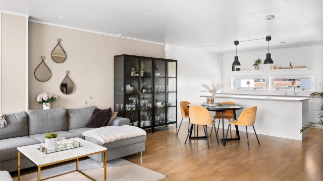 Gjennomgående parkett binder sammen stue og kjøkken. Downlights i taket gir god grunnbelysning.