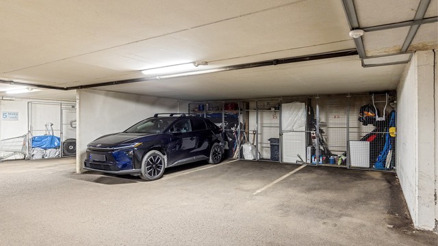Leiligheten har garasjeplass i felles anlegg under blokken, med heisadkomst fra garasjeplan til leilighetsplan. ( Parkeringsplass til høyre i bildet)