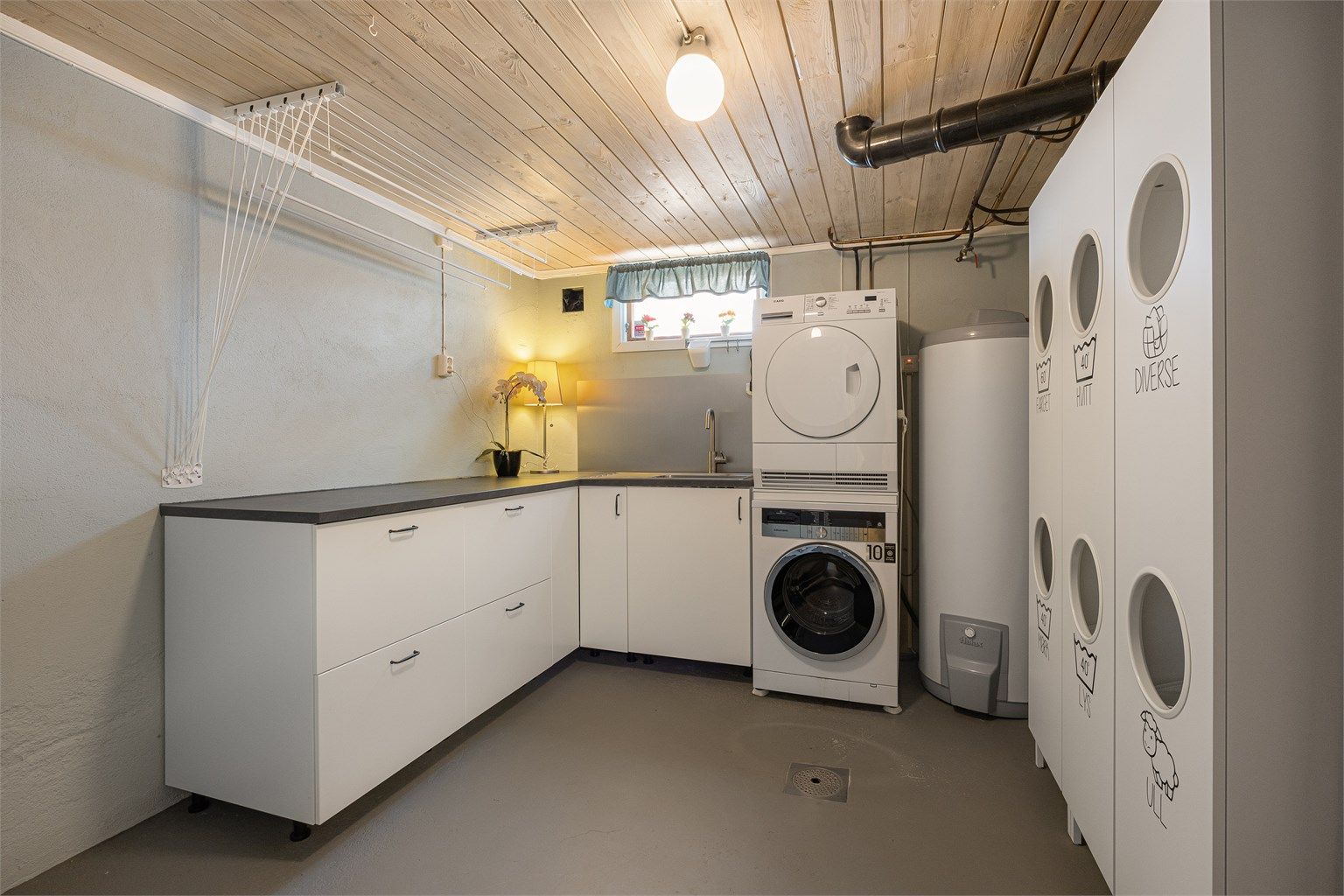 Vaskerommet i kjelleren er funksjonelt innredet og har en varmtvannstank på ca. 300 liter fra 2022.