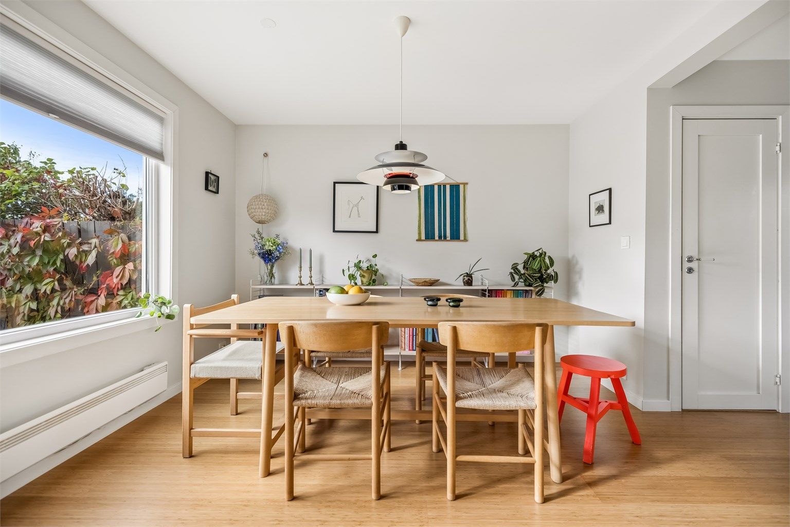 Spisestuen har store vindusflater som slipper inn rikelig med dagslys og gir godt gjennomlys – en lys og luftig atmosfære perfekt for både hverdagsmåltider og sosiale sammenkomster.